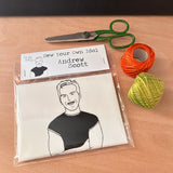 Sew Your Own Andrew Scott doll cushion craft kit. On a wooden surface with craft supplies.