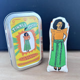 Mini doll of writer Chimamanda Ngozi Adichie and gift tin.