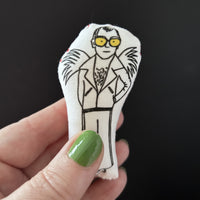 Mini illustrated Elton John doll.