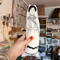 Black and white illustrated fabric doll featuring the suffragette Emmeline Pankhurst.