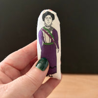 Mini illustrated fabric doll gift featuring feminist icon and most famous suffragette, Emmeline Pankhurst, held in a hand for scale.