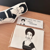 Sew Your Own singer songwriter, Nina Simone doll cushion craft kit. On a wooden surface with sewn example.