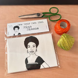 Sew Your Own singer songwriter, Nina Simone doll cushion craft kit. On a wooden surface with craft supplies.