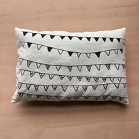 Reverse side of a Sew Your Own Queen Elizabeth II cushion craft kit on a wooden surface, featuring an illustrated bunting design.
