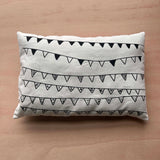 Reverse side of a Sew Your Own Queen Elizabeth II cushion craft kit on a wooden surface, featuring an illustrated bunting design.
