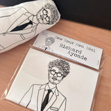 Sew Your Own Richard Ayoade doll cushion craft kit. On a wooden surface with a finished example.