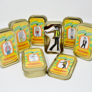 A selection of mini fabric dolls of celebrity figures in tins, called Tinned Idols.