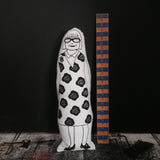 Black and white screen printed doll featuring an illustration of The Great British Sewing Bee host Esme Young. Stood beside a wooden vintage ruler against a black wall to indicate size.