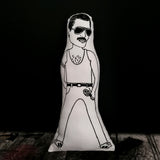 Black and white screen printed fabric doll of Queen frontman Freddie Mercury. Stood against a black wall.