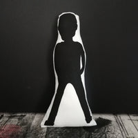 Reverse of black and white screen printed doll cushion featuring the silhouette of Freddie Mercury. Stood against a black wall. 
