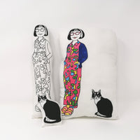 Black and white screen printed fabric doll beside a coloured cushion version of a screen printed Philippa Perry and cat doll.