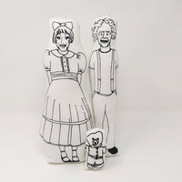 Black and white screen printed fabric dolls of Grayson Perry, Claire and Alan Measles against a white background