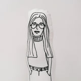 Close up of a black and white screen printed fabric doll of Gloria Steinem.