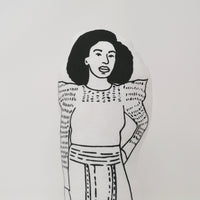 Close up of black and white illustrated screen printed fabric doll of Chimamanda Adiche