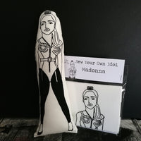 Black and white fabric doll featuring an illustration of Madonna and a craft kit.