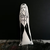 Black and white fabric doll featuring an illustrated design of Madonna. All set against a black wall.