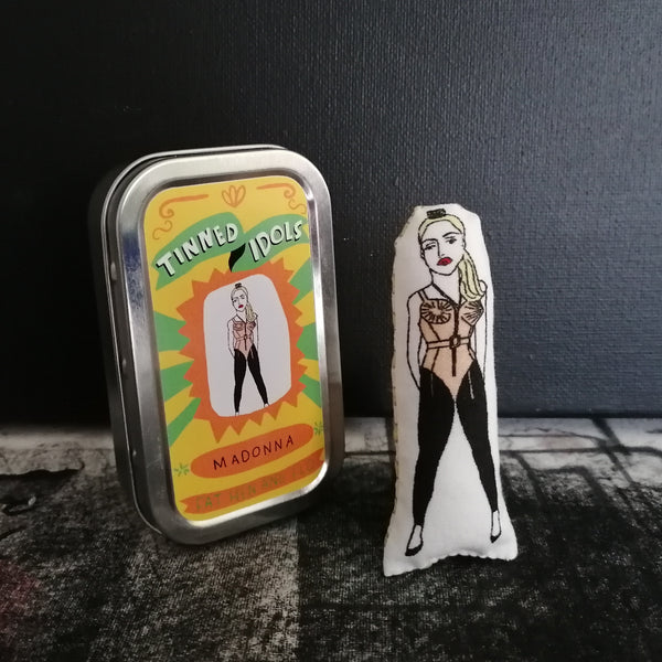 Mini fabric doll featuring an illustration of Madonna beside a gift tin with sticker detail lid.