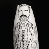 A close up of a  black and white screen printed fabric doll featuring an illustration of The Great British Sewing Bee host Patrick Grant.