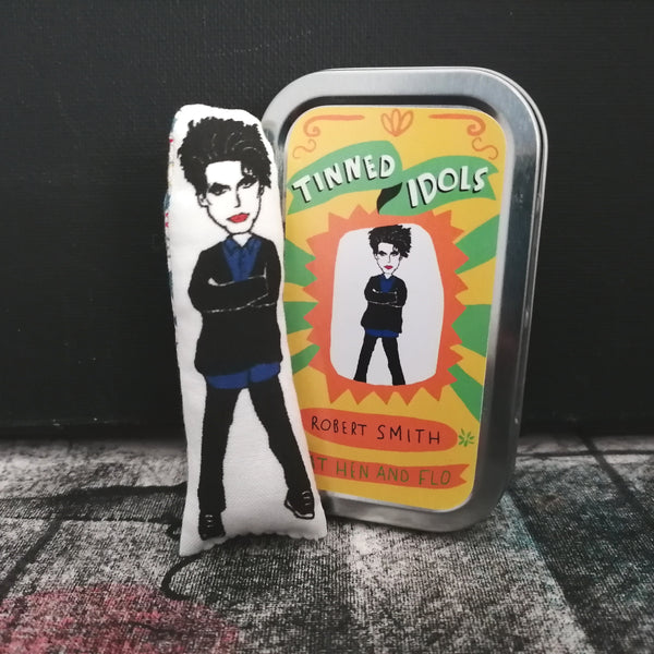 Mini Robert Smith fabric doll and gift tin against a black background.
