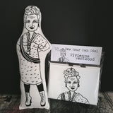 Black and white fabric screen printed doll beside a craft kit. Both feature fashion designer Vivienne Westwood.