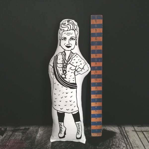 Black and white screen printed fabric doll of fashion designer Vivienne Westwood stood beside a vintage wooden ruler for scale. All against a black background.
