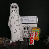 A selection of gifts of Japanese artist Yayoi Kusama including a screen printed fabric doll, a craft kit and mini doll in a tin.