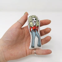 Mini fabric doll of Dolly Parton held in a hand to show scale.