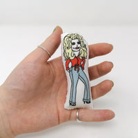 Mini fabric doll of Dolly Parton in a hand to show the size of the doll.