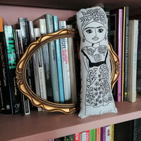 Frida Kahlo monochrome fabric doll on a bookshelf