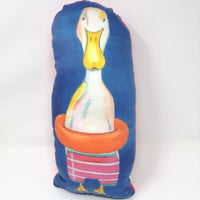 Aves The Duck, illustrated duck cushion. White duck with pink shorts and a rubber ring on a blue background.
