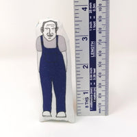 Mini fabric doll of Keith Brymer Jones from The Great Pottery Throw Down standing beside a metal ruler to show that he is 9cm tall.